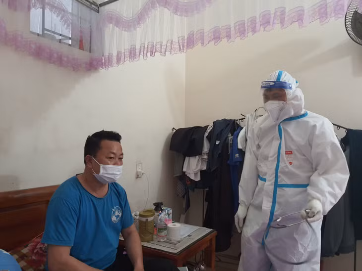 Y sĩ Hoàng Văn Thái, Trạm trưởng Trạm y tế lưu động xã Quảng Tân đang thăm khám tư vấn cho bệnh nhân F0 tại nhà.