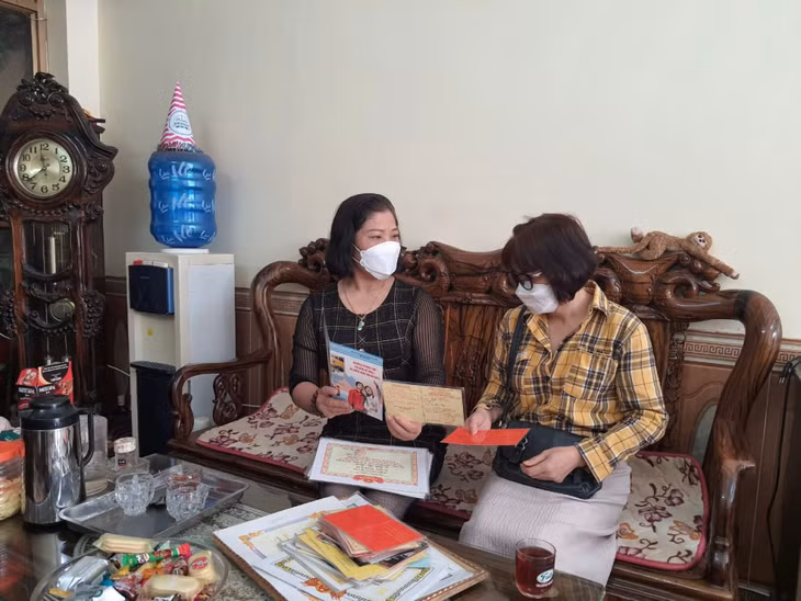 Chị Trần Thị Minh (trái) tuyên truyền, vận động hàng xóm tham gia hiến máu.