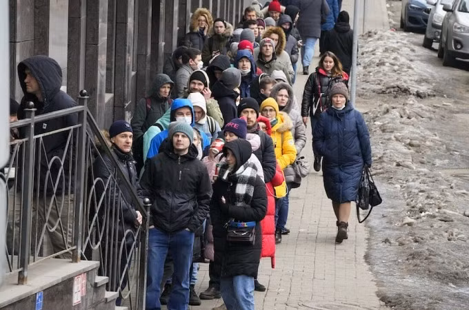 Người Nga xếp hàng chờ rút tiền tại cây ATM ở St. Petersburg hôm 25/2. Ảnh: AP.
