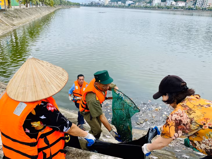 Cán bộ, hội viên Hội phụ nữ khu phố 1 (phường Hùng Thắng) tham gia vớt rác thải tại hồ Hùng Thắng.