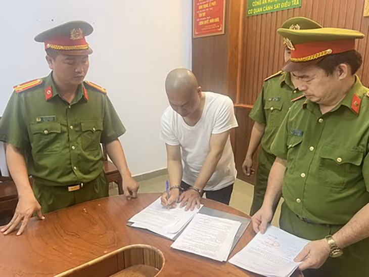 Cơ quan tố tụng tống đạt các quyết định khởi tố bị can và thi hành lệnh bắt tạm giam ông Nguyễn Minh Phúc. Ảnh: CA