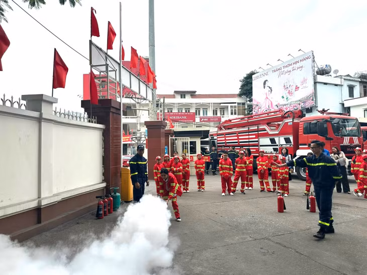 Các em thiếu nhi được hướng dẫn dập lửa bằng bình cứu hỏa.