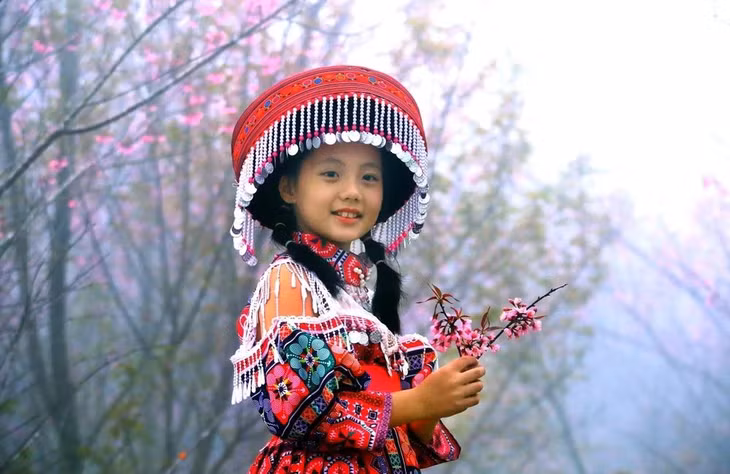 Bé gái thích thú khi được gia đình đưa đi tham quan, ngắm các loài hoa đua nở tại khu du lịch Pha Đin Top trên đèo Pha Đin