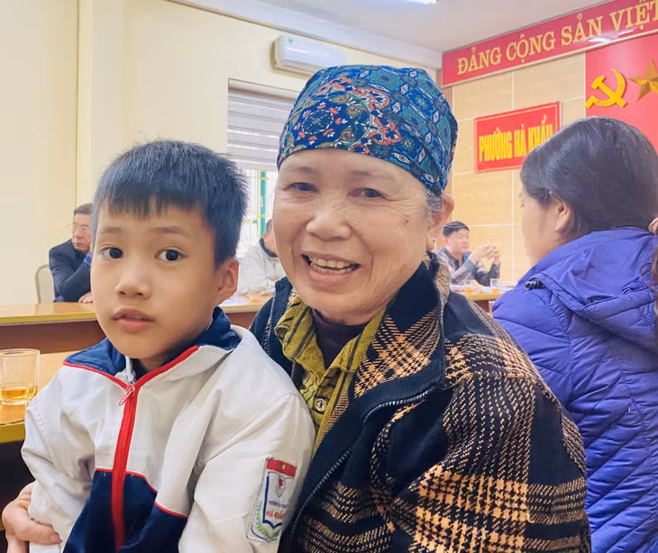 Niềm vui của bà cháu em Lương Cao Nhất (phường Hà Khẩu) trong buổi lễ bàn giao nhận đỡ đầu do phường tổ chức.