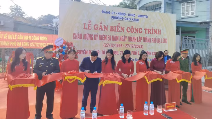 Các đại biểu thực hiện nghi thức gắn biển công trình cải tạo nâng cấp tuyến đường dân sinh thuộc tổ 69A, tổ 69C, tổ 71, khu 6, phường Cao Xanh.
