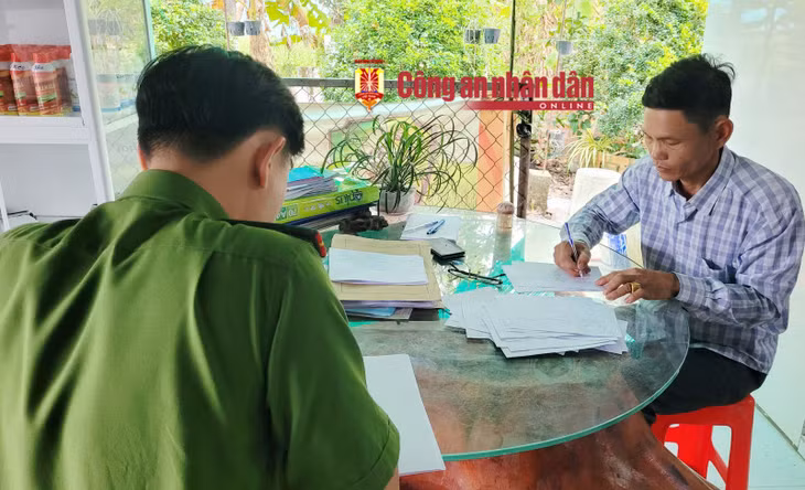 Đối tượng Huân (bìa phải) ký vào biên bản vi phạm.