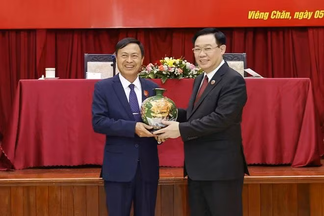 Chủ tịch Quốc hội Vương Đình Huệ tặng quà ông Phạm Văn Hùng, Chủ tịch Ban Chấp hành Tổng Hội người Việt Nam tại Lào nhiệm kỳ 2022-2026. (Ảnh: Doãn Tấn/TTXVN)