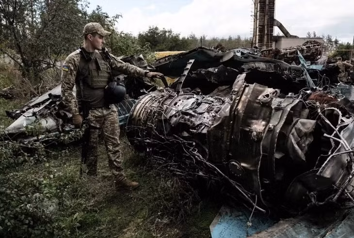 Một sĩ quan quân đội Ukraine đứng cạnh mảnh vỡ của máy bay được cho là Su-34 Nga bị bắn rơi ở Lyman thuộc vùng Donetsk vào ngày 5/10/2022. Ảnh minh hoạ: Getty