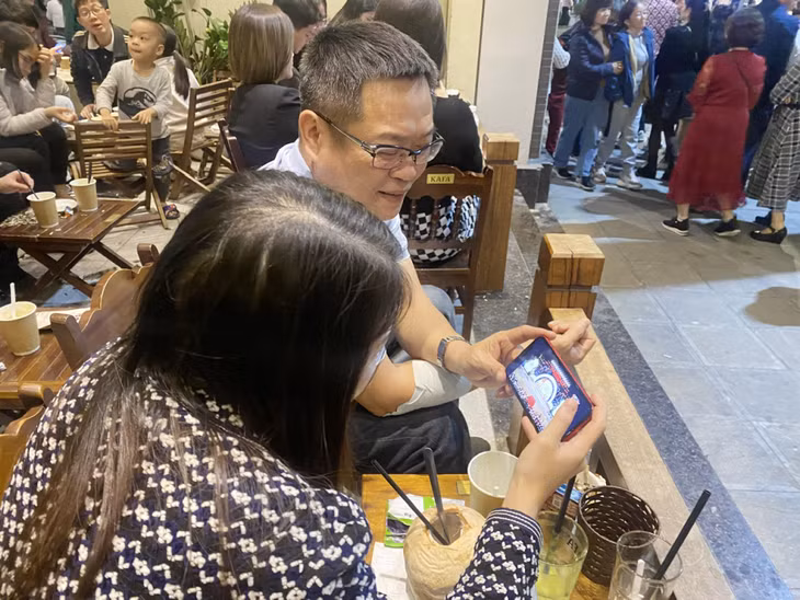 Người dân xem lễ kỷ niệm qua truyền hình trực tiếp trên sóng QTV.
