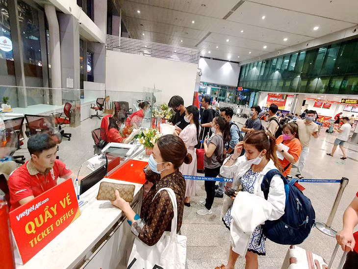 Hành khách mua vé máy bay tại quầy của Vietjet tại sân bay Tân Sơn Nhất, TP.HCM - Ảnh: CÔNG TRUNG