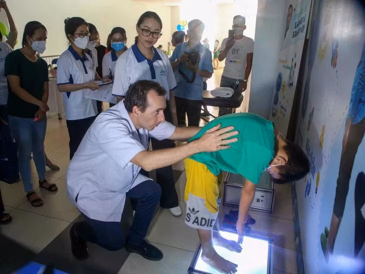 Khám tầm soát bệnh vẹo cột sống cho trẻ em. (Ảnh: Trần Lê Lâm/TTXVN)