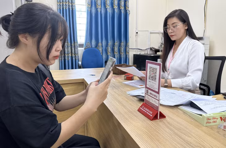 Người dân xã Cẩm La (TX Quảng Yên) quét mã QR để nộp lệ phí tại Bộ phận tiếp nhận và trả kết quả hiện đại của xã.