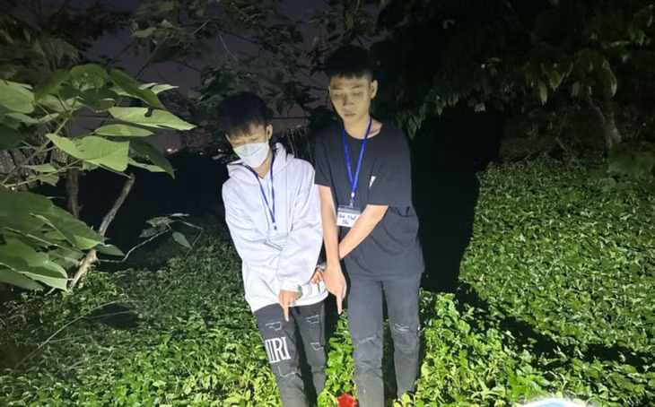 Hai đối tượng trong nhóm của Ninh Gia Nam được dẫn giải đi thực nghiệm hiện trường, chỉ địa điểm cất giấu hung khí.