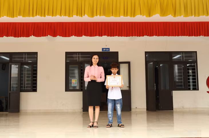 Bà Nguyễn Thị Lan Anh, Phó Chủ tịch UBND thị trấn Cô Tô tặng giấy khen cho em Đỗ Việt Hoàng. Ảnh: Thu Báu (Trung tâm TT&amp;VH huyện Cô Tô)