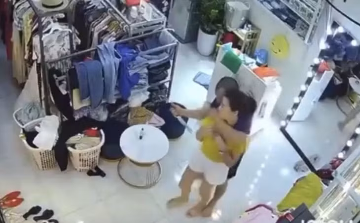 Hình ảnh cắt từ clip chủ cửa hàng quần áo bị đối tượng Cương cầm dao đe dọa.
