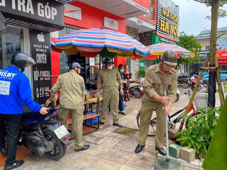 Đội TTĐT thu dọn các cây, cọc lấn chiếm hành lang vỉa hè.