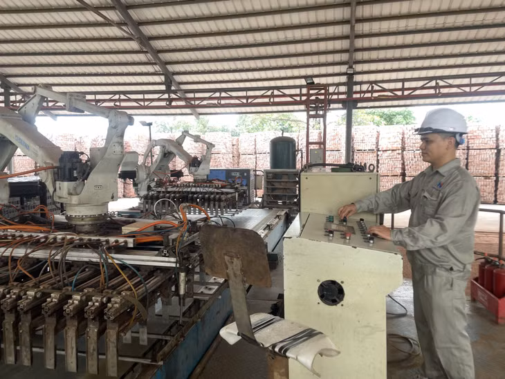 Anh Triệu Văn Mạnh (Công ty TNHH Liên doanh gốm xây dựng Hoàng Quế) điều khiển robot xếp gạch.