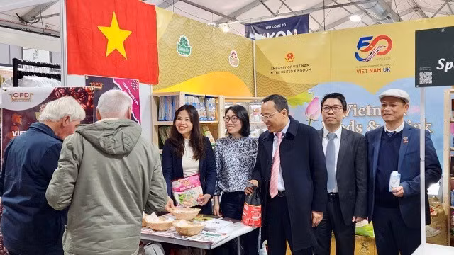 Khách thăm quan thưởng thức, khen ngợi hoa quả nhiệt đới sấy dẻo của Việt Nam. Ảnh: TTXVN phát