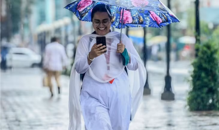 Một phụ nữ dùng điện thoại khi đang đi bộ trên đường phố Srinagar, Ấn Độ. Ảnh: AFP