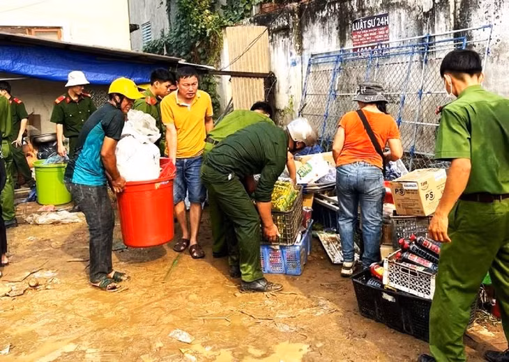 Lực lượng Công an huyện Ea Súp hỗ trợ người dân di chuyển hàng hóa ra khỏi chợ.
