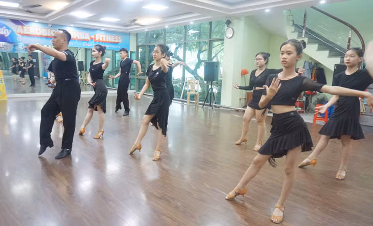 Trần Nguyễn Ngọc Minh (hàng trên, bên phải) tập luyện dancesport cùng bố và các bạn trong CLB khiêu vũ thể thao Cường Anh (Đông Triều).