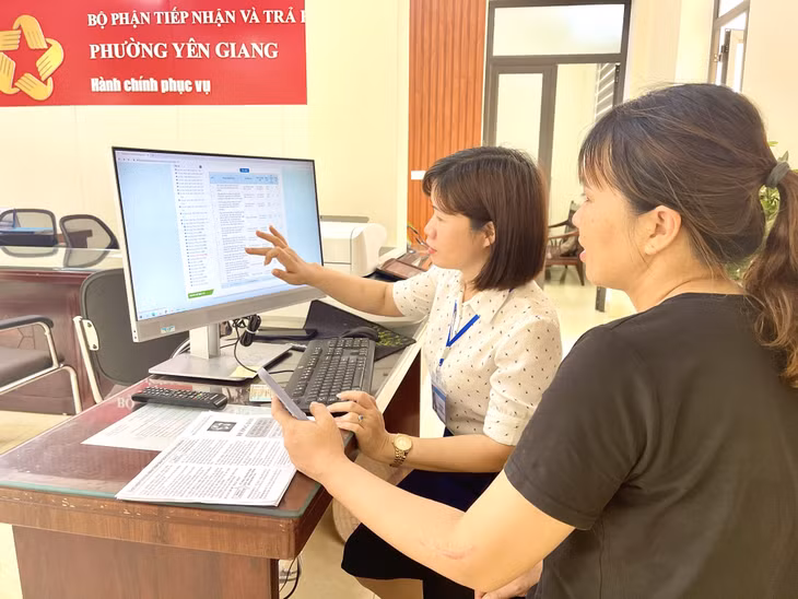 Cán bộ phường Yên Giang hướng dẫn người dân vào cổng dịch vụ công trực tuyến.