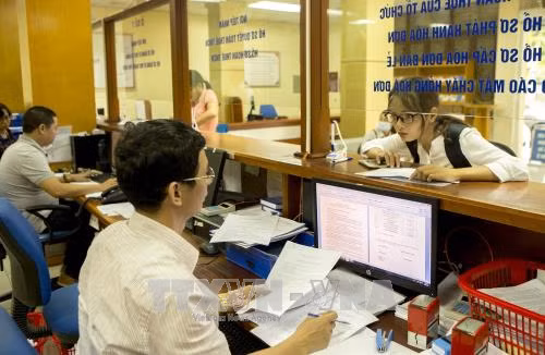 Người dân, doanh nghiệp nộp thuế. Ảnh minh họa: TTXVN