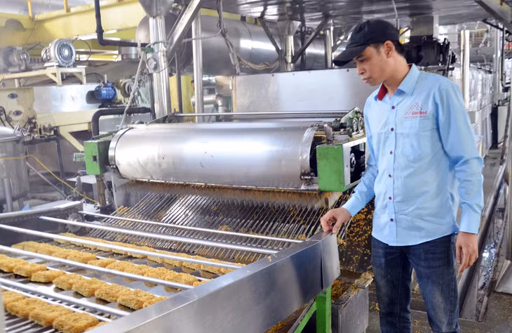 Kỹ sư Nguyễn Văn Huynh giám sát hệ thống dây chuyền sản xuất mì ăn liền tại Công ty.