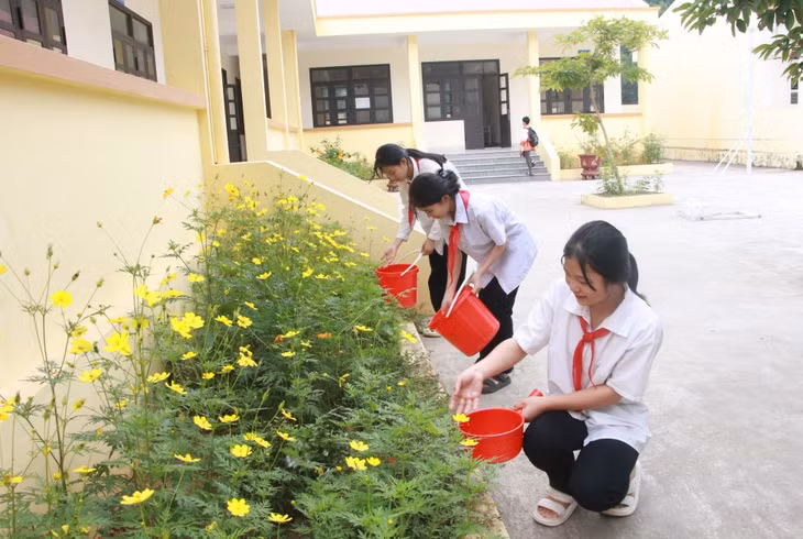 Học sinh Trường THCS Vô Ngại chăm sóc cây hoa trong vườn trường.