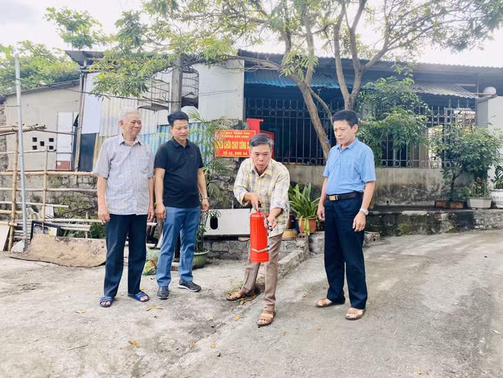 Đại diện tổ 42, khu phố 4A (phường Cao Xanh) hướng dẫn người dân trong khu phố cách thức sử dụng bình chữa cháy tại "Điểm chữa cháy công cộng".
