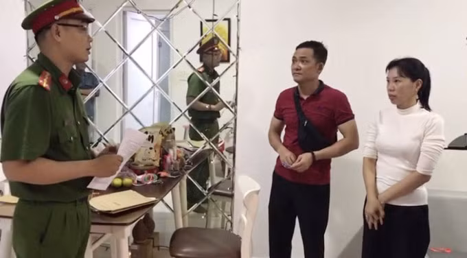 Cảnh sát đọc lệnh bắt bị can. Ảnh: Tường Vân
