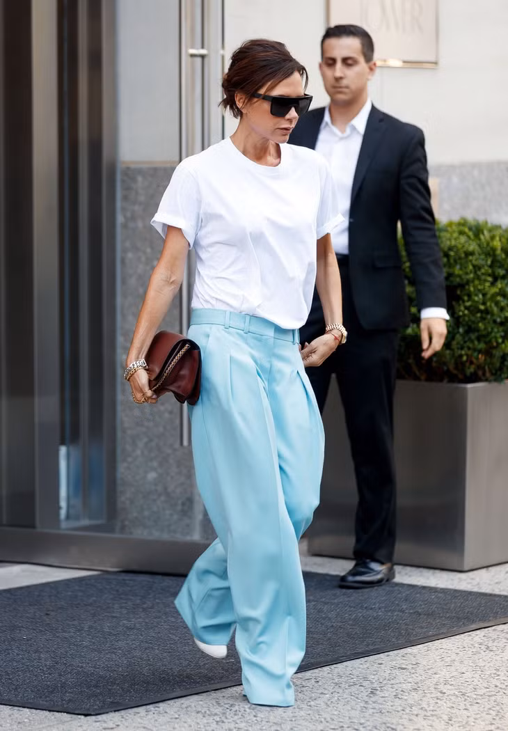 Trong số các ngôi sao thời trang, Victoria Beckham nằm trong nhóm có nhiều trang phục công sở ấn tượng nhất. Bạn có thể học nhà thiết kế cách phối áo phông trắng và quần vải ống suông, giày gót nhọn màu nổi. Ảnh: SplashNews