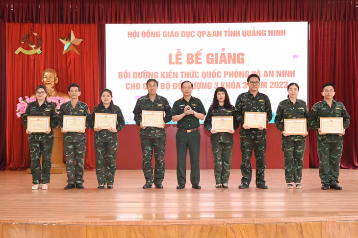 Đại tá Nguyễn Quang Hiến, Phó Bí thư Thường trực Đảng ủy, Chính ủy Bộ CHQS tỉnh, Ủy viên Hội đồng giáo dục QPAN tỉnh Quảng Ninh, trao giấy chứng nhận hoàn thành chương trình bồi dưỡng kiến thức QPAN đối tượng 3 cho các học viên tại Lễ bế giảng.