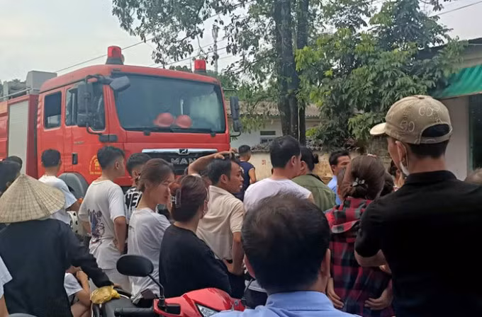 Nggười dân theo dõi lực lượng chức năng cứu hộ nạn nhân. Ảnh: Lam Sơn