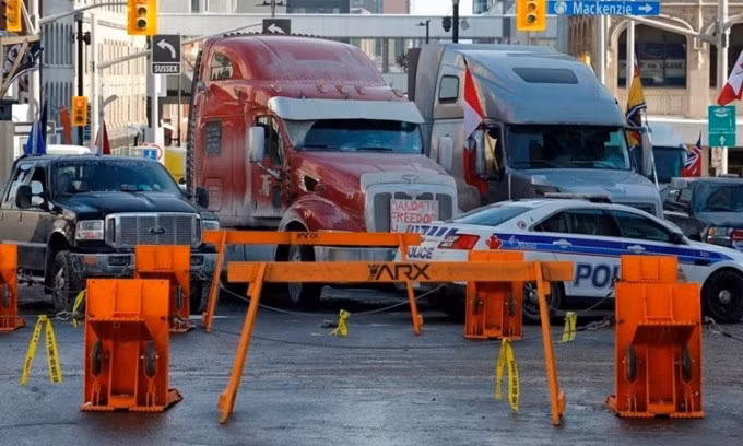 Những chiếc xe tải tham gia biểu tình dừng trước rào chắn của cảnh sát ở thủ đô Ottawa, Canada, ngày 1/2. Ảnh: Canadian Press.