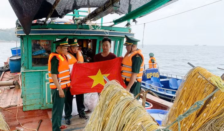 CBCS Đồn Biên phòng Đảo Trần tặng cờ Tổ quốc cho ngư dân vươn khơi bám biển.