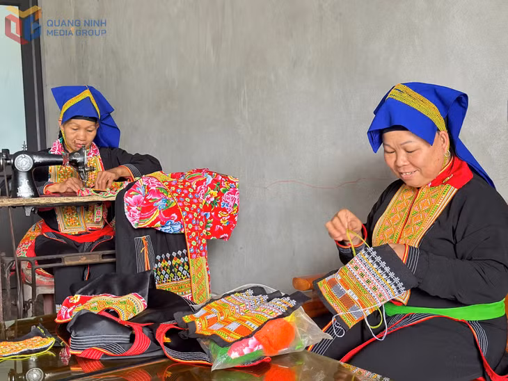 Bà Bàn Thị Xuân (bên trái), cùng phụ nữ xã Đồn Đạc, huyện Ba Chẽ giữ nghề may thêu trang phục truyền thống dân tộc Dao.