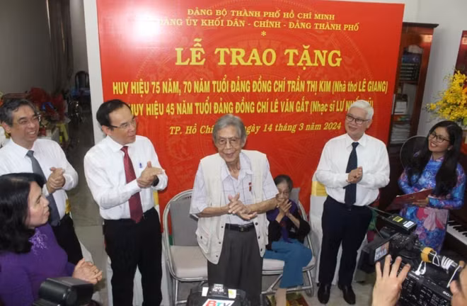 Bí thư Thành ủy Thành phố Hồ Chí Minh Nguyễn Văn Nên trao huy hiệu Đảng cho nhà thơ Lê Giang và nhạc sỹ Lư Nhất Vũ. (Ảnh: Chí Tưởng/TTXVN)