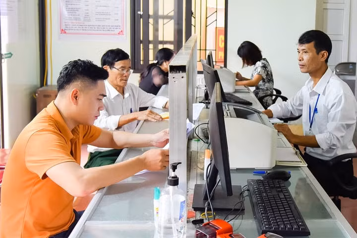 Cán bộ làm việc tại bộ phận một cửa phường Quỳnh Thiện (thị xã Hoàng Mai, tỉnh Nghệ An) giải quyết thủ tục hành chính cho người dân. (Ảnh: Báo Nghệ An)