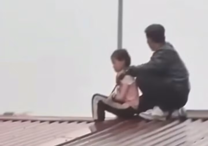 Cháu bé bị gã đàn ông khống chế, đưa lên mái nhà.