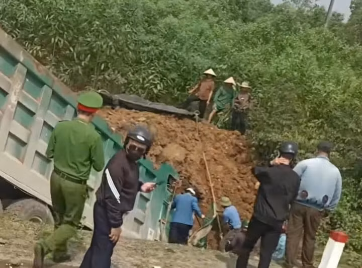 Lực lượng chức năng đang đào đất cứu hộ, tìm cách đưa thi thể tài xế ra ngoài. (Ảnh: CTV)