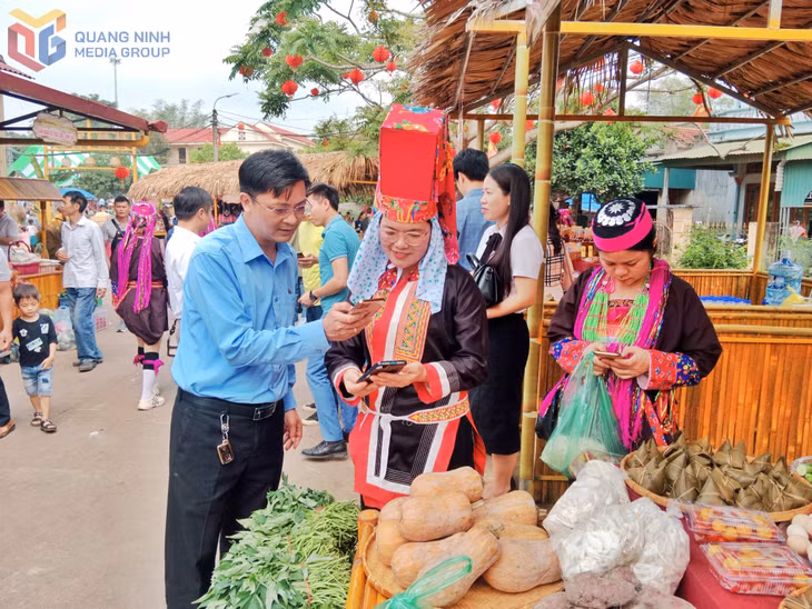 Người dân thực hiện thanh toán không dùng tiền mặt bằng mã QR khi mua hàng tại chợ phiên Hà Lâu (huyện Tiên Yên).