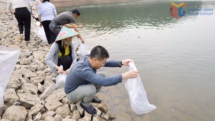 Các đại biểu và nhân dân TP Móng Cái thả hơn 80.000 con giống thuỷ sản ra lòng hồ Tràng Vinh ngày 28/3
