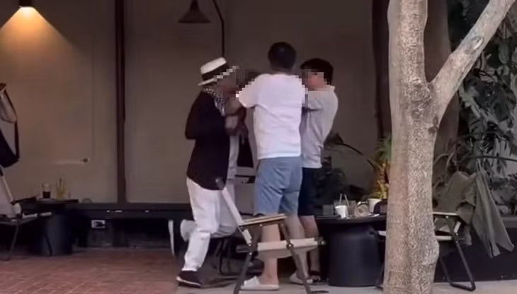 Người đàn ông ăn mặc giống một doanh nhân nổi tiếng đánh nhau trong quán cà phê ở TP Thủ Đức - Ảnh: Cắt từ clip