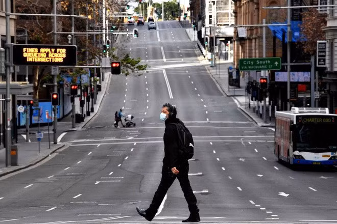 Người đàn ông đi trên con đường vắng vẻ ở Sydney, Australia ngày 26/6 (Ảnh: AFP).