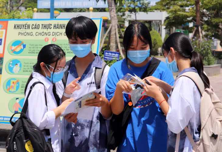 Dù giữa trưa nắng gắt nhưng nhiều thí sinh vẫn nán lại trường thi tranh thủ trao đổi lại bài thi với bạn bè.