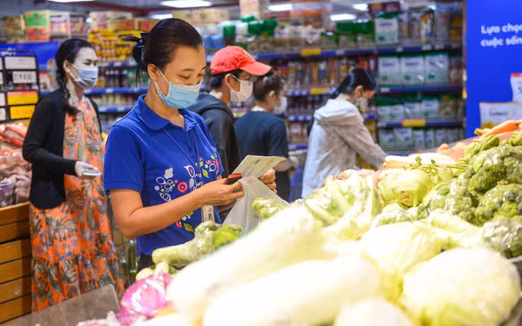 Nhân viên siêu thị tại Phú Nhuận (TP.HCM) “đi chợ” cho khách mua online - Ảnh: Q.ĐỊNH