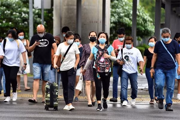 Người dân Singapore đeo khẩu trang khi đi ngoài đường. Ảnh: Reuters Singapore lên lộ trình sống chung với Covid-19