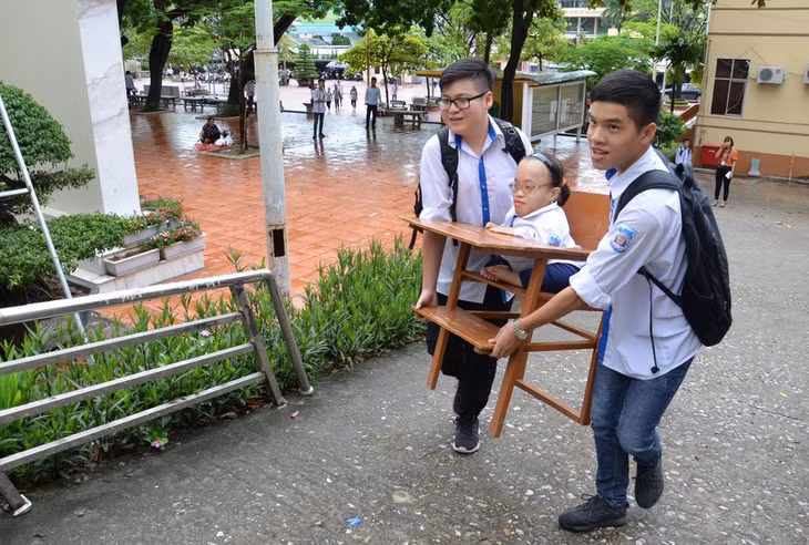 Kỳ thi tốt nghiệp THPT năm 2018, Hoài Thương được bạn bè đưa đến phòng thi trên bộ bàn ghế đặc biệt. Ảnh: Lan Anh