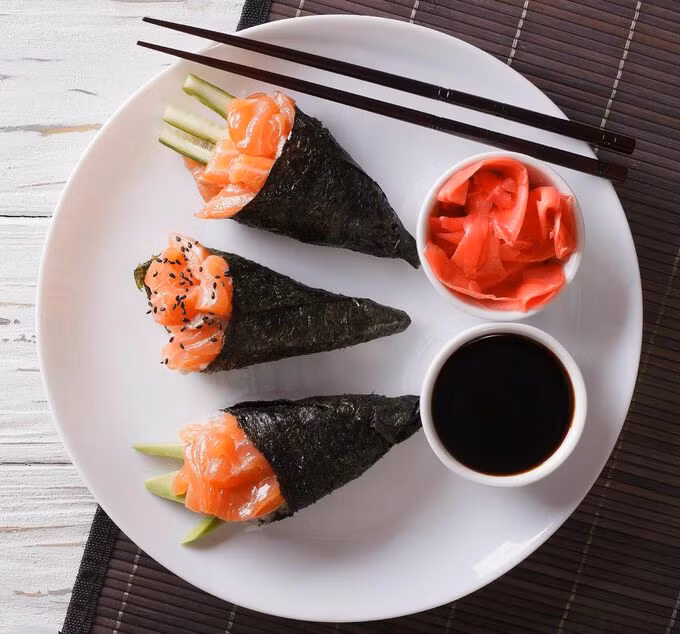 Temaki: Temaki nghĩa là "cuộn tay", đó cũng là cách chế biến loại sushi này, dùng rong biển bọc cơm và rau củ, cá rồi cuộn thành hình phễu khá lỏng tay. Khi làm xong temaki nhìn giống một que kem ốc quế. Thực khách khi ăn chỉ việc cầm tay ăn không nhất thiết dùng đũa. Ảnh: Pinterest